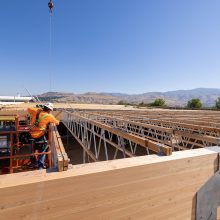 construction worker on the roof of a building with exposed framing